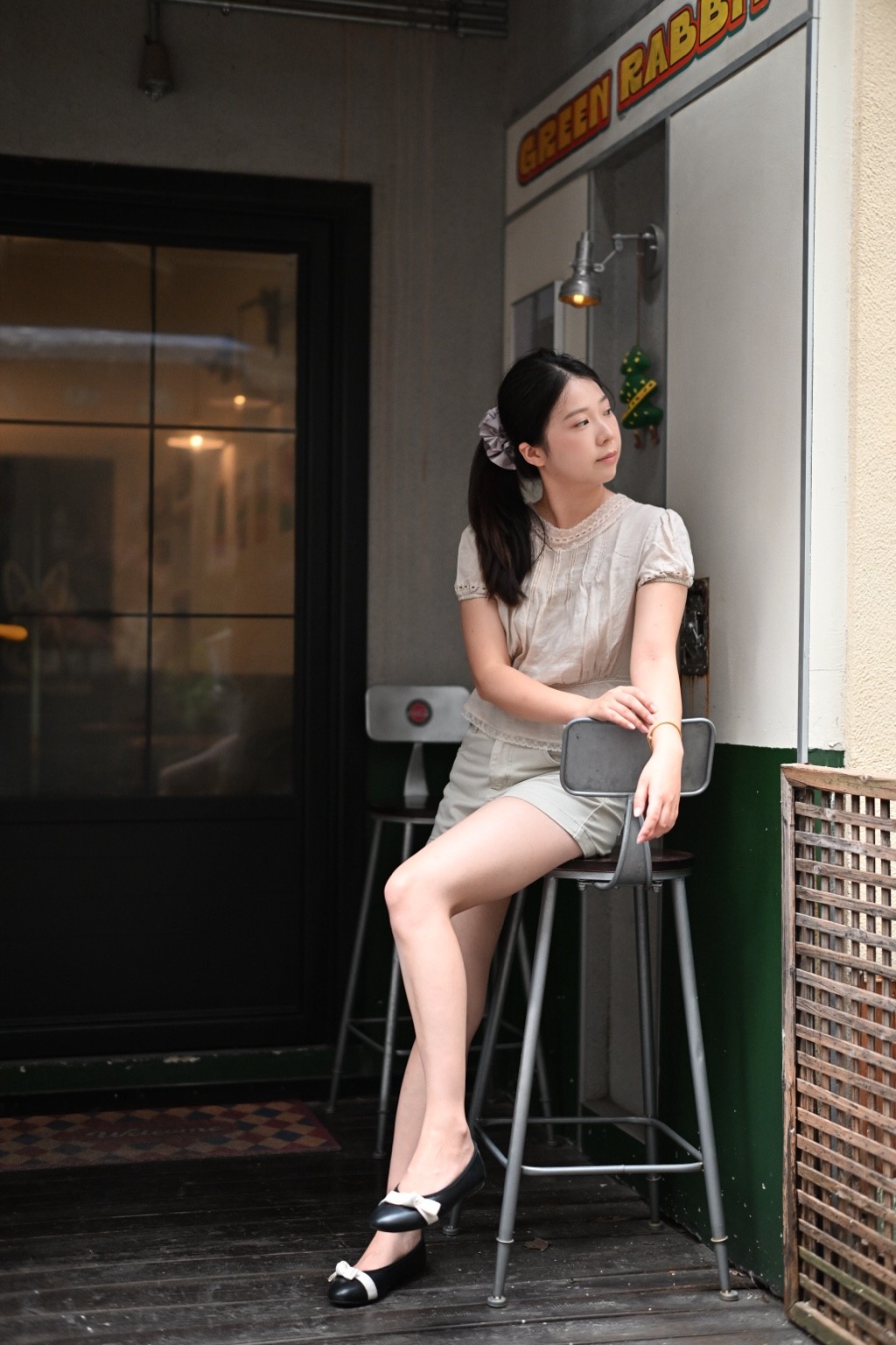 咖啡馆门口高脚凳上的女子